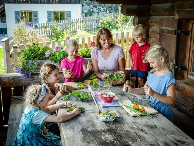 Die Bäuerin Gabi macht mit den Kindern eine Kräutersalbe.