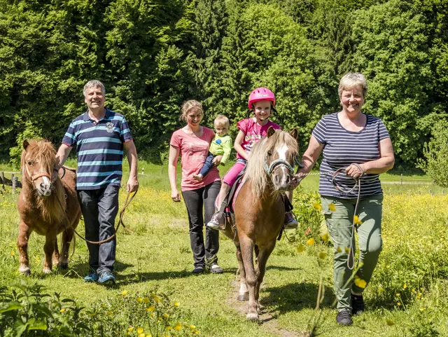 Urlaubsgäste machen eine geführte Ponywanderung.