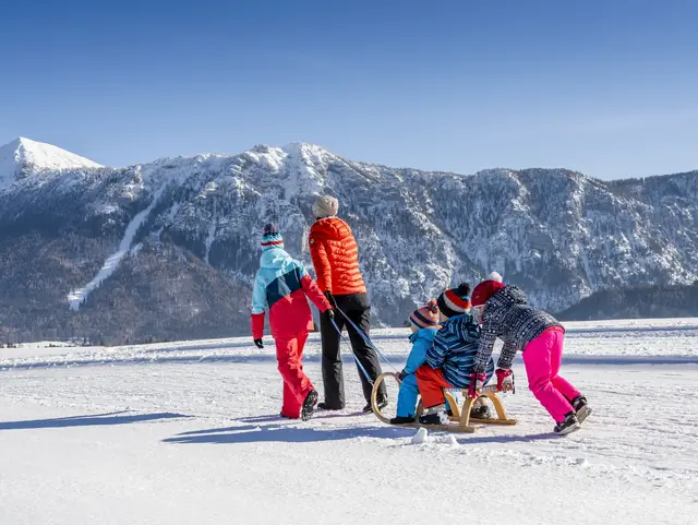 Familienausflug mit dem Schlitten auf dem Schnee